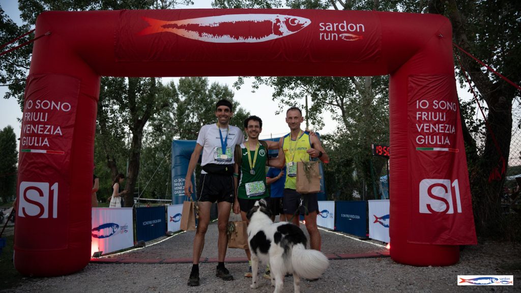 Premiazione sul podio sotto l'arco rosso Sardon Run, con un cane tra i protagonisti