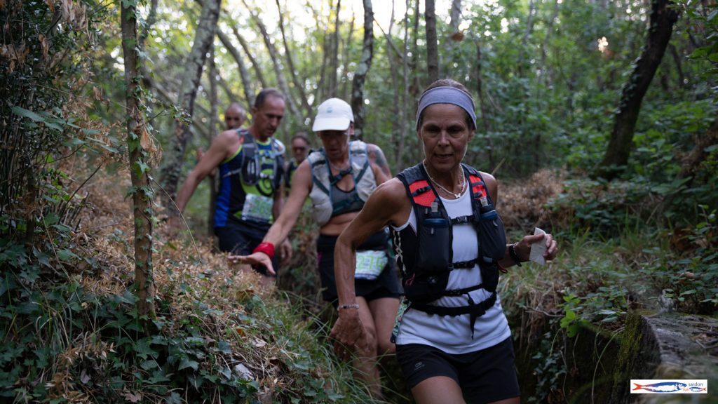 Gruppo di trail runner in fila sul single track nel bosco del Carso — Sardon Run