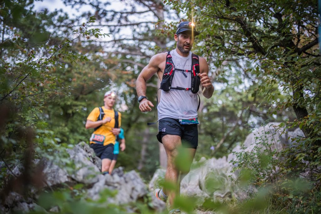 Due trail runner in salita sul single track roccioso tra la vegetazione del Carso triestino — Sardon Run